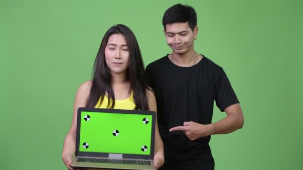 Jovem casal asiático mostrando laptop e dando polegares para cima — Vídeo de Stock