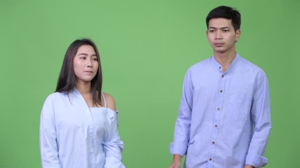 Joven asiático negocios pareja mostrando algo juntos — Vídeo de stock