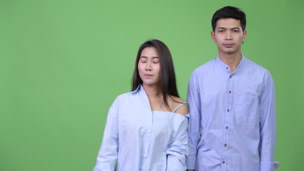Jovem asiático casal de negócios mostrando algo juntos — Vídeo de Stock