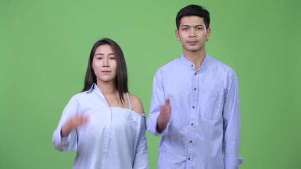 Молодая азиатская бизнес-пара, пожимая друг другу руки — стоковое видео