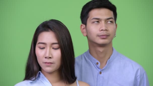 Молодая азиатская пара думает вместе по-другому — стоковое видео