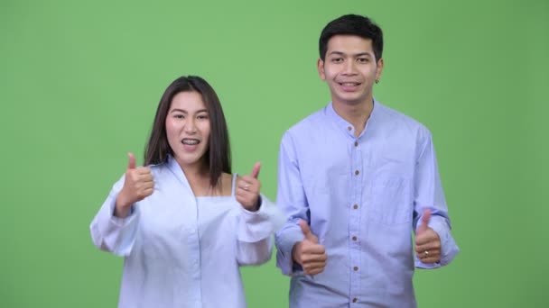 Jeune couple d'affaires asiatique heureux donnant pouces ensemble — Video