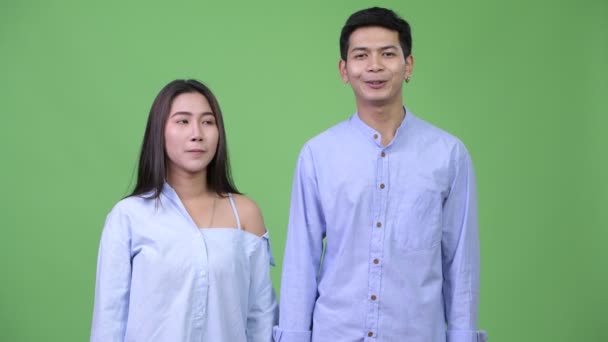 Молодая азиатская бизнес-пара разговаривает с камерой вместе — стоковое видео