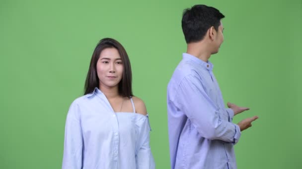 Молодая азиатская бизнес-пара представляет что-то вместе — стоковое видео