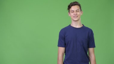Genç yakışıklı genç çocuk bir şeyler gösteriyor