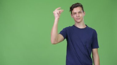 Genç yakışıklı genç çocuk bir şeyler gösteriyor