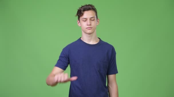 Mladý pohledný dospívající chlapec dává palec dolů — Stock video