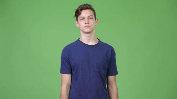 Jovem adolescente bonito apontando para a câmera — Vídeo de Stock