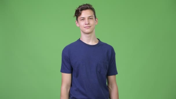 Молодой симпатичный подросток указывает на камеру — стоковое видео