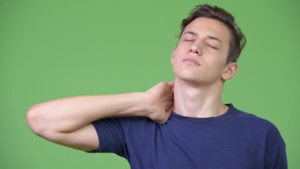Jonge knappe tiener jongen met nekpijn — Stockvideo