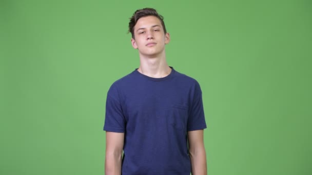 Joven guapo adolescente relajándose con los ojos cerrados — Vídeos de Stock