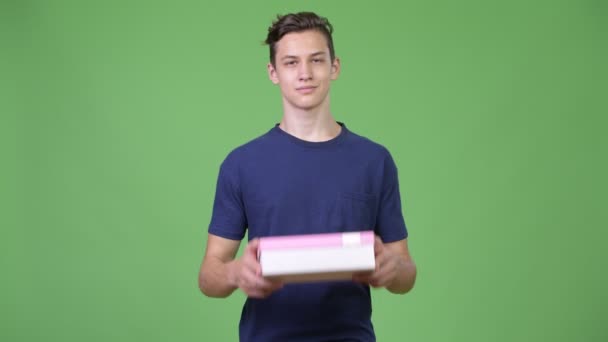 Mladý pohledný dospívající chlapec dává krabičky — Stock video