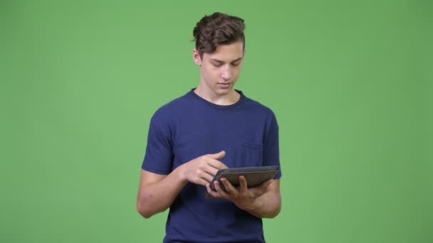 Junger hübscher Teenager mit digitalem Tablet — Stockvideo