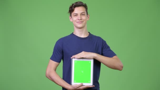 Junge hübsche Teenager zeigen digitales Tablet — Stockvideo