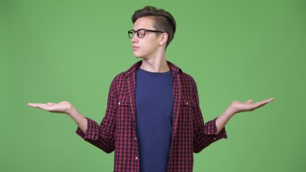Jovem bonito adolescente nerd menino comparando — Vídeo de Stock