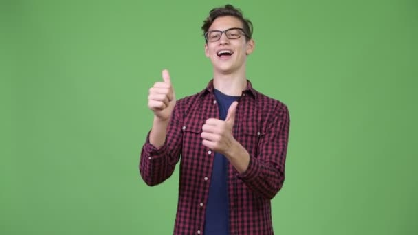 Jovem bonito adolescente nerd menino dando polegares para cima — Vídeo de Stock