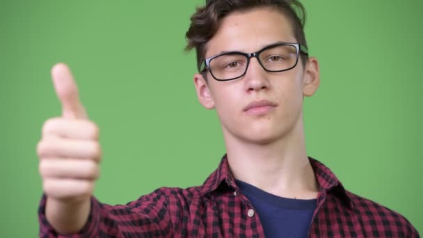 Jovem bonito adolescente nerd menino dando polegares para cima — Vídeo de Stock