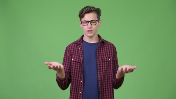 Young handsome teenage nerd boy shrugging — Stock Video