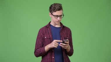 Genç, yakışıklı inek çocuk telefon kullanıyor.