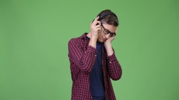 Joven guapo adolescente nerd chico escuchando música — Vídeo de stock