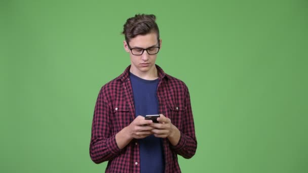 Jovem bonito adolescente nerd menino usando telefone — Vídeo de Stock