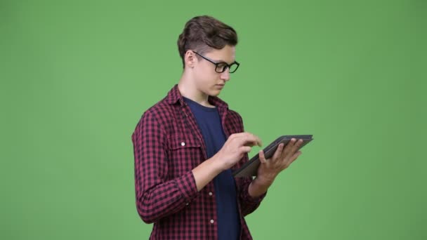 Junge hübsche Teenager-Nerd-Junge mit digitalem Tablet — Stockvideo