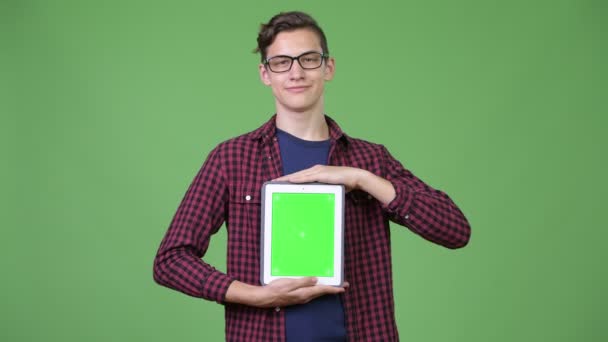 Jeune beau adolescent geek garçon montrant tablette numérique — Video