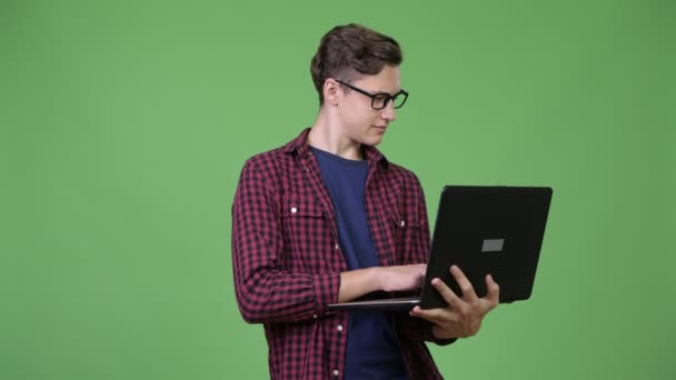 Genç yakışıklı genç inek çocuk dizüstü bilgisayar kullanarak — Stok video