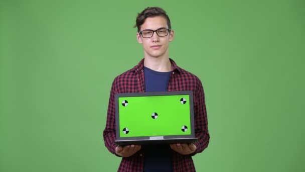 Jovem bonito adolescente nerd menino mostrando laptop — Vídeo de Stock