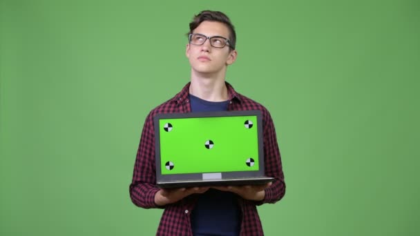 Jonge knappe tiener nerd jongen met laptop — Stockvideo