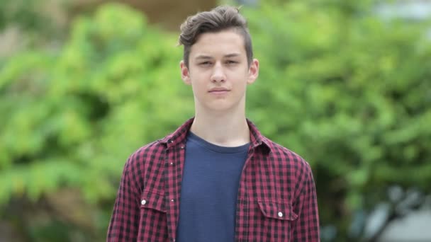 Junge glückliche hübsche Teenager-Junge im Freien — Stockvideo