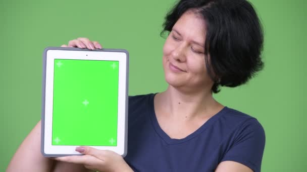 Schöne Frau mit kurzen Haaren zeigt digitales Tablet — Stockvideo