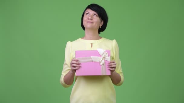 Schöne Geschäftsfrau denken mit Geschenk-Box — Stockvideo