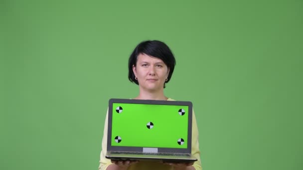 Hermosa mujer de negocios con el pelo corto que muestra el ordenador portátil mientras se ve sorprendido — Vídeo de stock