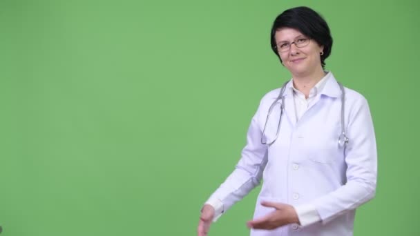 Mulher bonita médico com cabelo curto mostrando algo — Vídeo de Stock