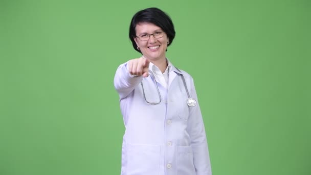 Beautiful woman doctor with short hair pointing at camera — Stock Video