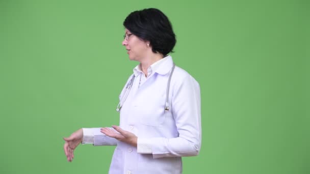 Όμορφη γυναίκα γιατρός με κοντά μαλλιά παρουσιάζει κάτι — Αρχείο Βίντεο