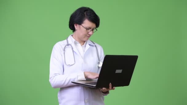 Hermosa mujer médico con el pelo corto usando el ordenador portátil — Vídeo de stock