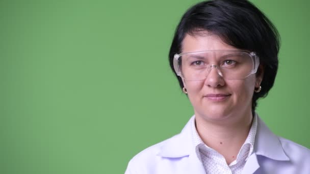 Счастливая красивая женщина врач думает, во время ношения защитных очков — стоковое видео