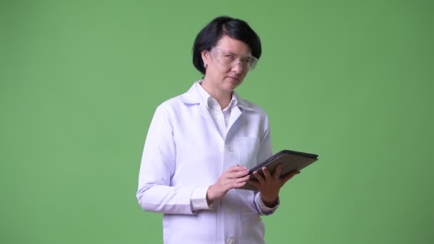 Güzel bir kadın doktor koruyucu gözlük takan ve dijital tablet kullanma — Stok video