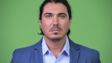 Yeşil arka planı gülümseyen yakışıklı işadamı