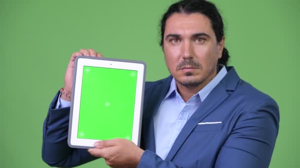 Glücklicher gutaussehender Geschäftsmann zeigt digitales Tablet — Stockvideo