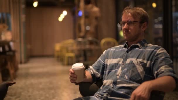 Schöner Geschäftsmann denkt beim Kaffeetrinken — Stockvideo