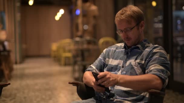 Przystojny biznesmen siedzi podczas korzystania z telefonu — Wideo stockowe
