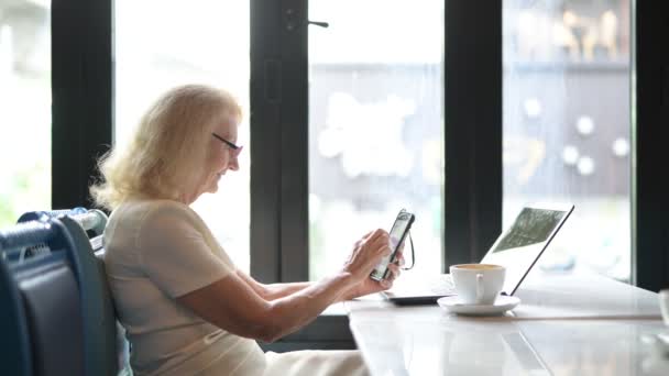 Feliz anciana mayor mujer usando el teléfono móvil y el portátil — Vídeo de stock