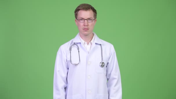 Porträt eines jungen Mannes Arzt zeigt mit dem Finger — Stockvideo