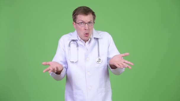 Doutor culpado encolhendo ombros e cobrindo a boca — Vídeo de Stock