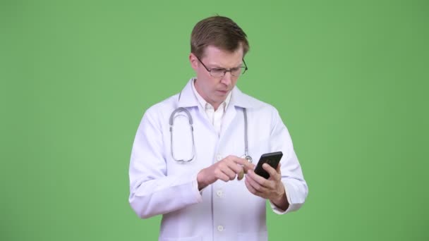 Frustrado hombre médico usando el teléfono móvil y recibiendo malas noticias — Vídeo de stock