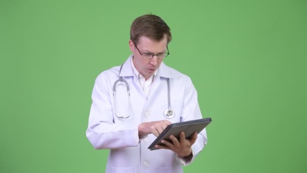 Felice uomo medico utilizzando tavoletta digitale e mostrando croma chiave schermo verde — Video Stock