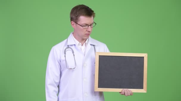 Man Doctor Holding Empty Blackboard With Copyspace — Stock Video